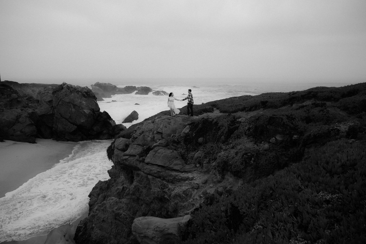 Misty coastal cliffs overlooking a dramatic ocean landscape in moody weather.