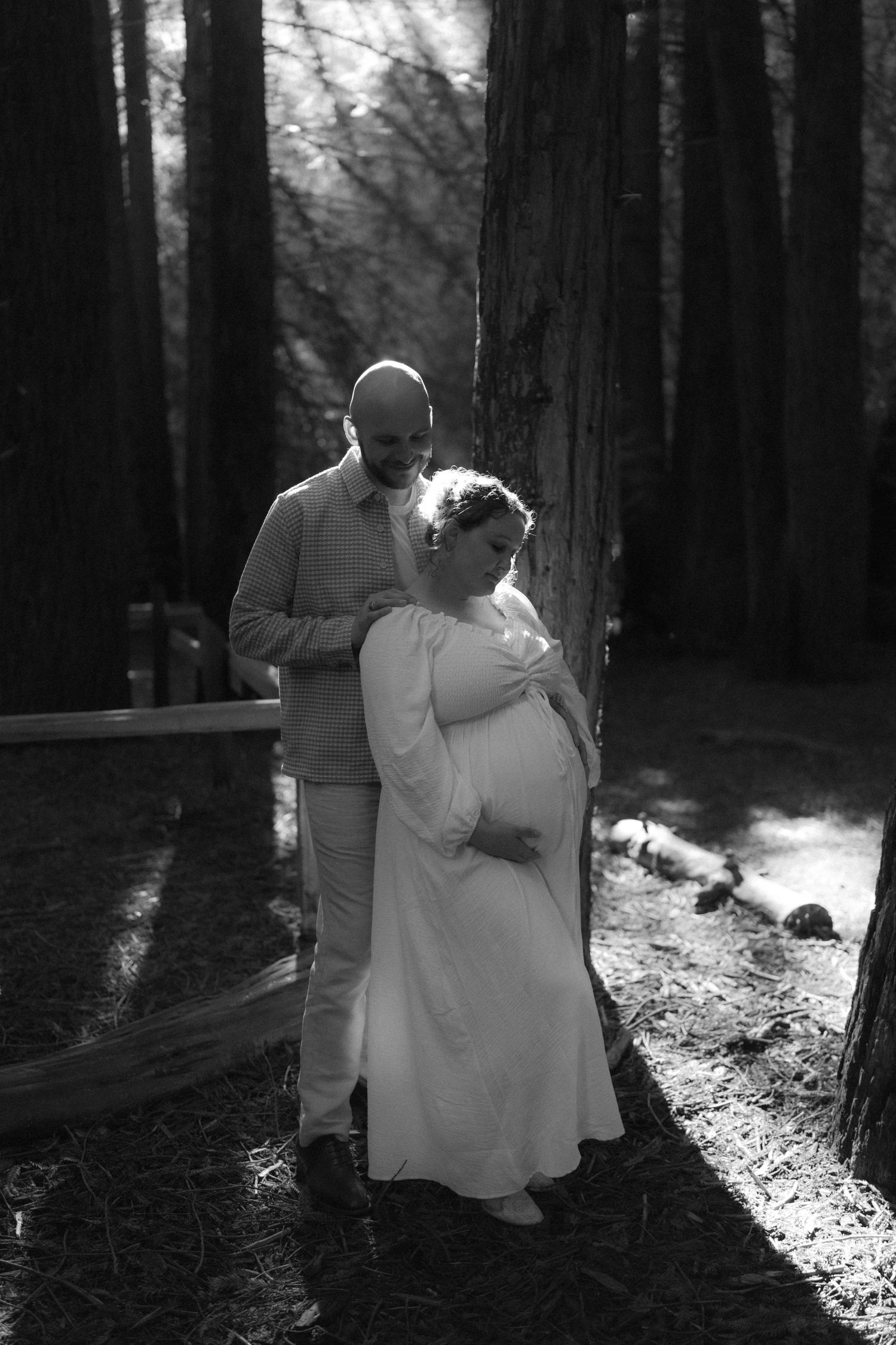 Romantic dance sequence photographed in black and white among tall forest trees with dramatic lighting.