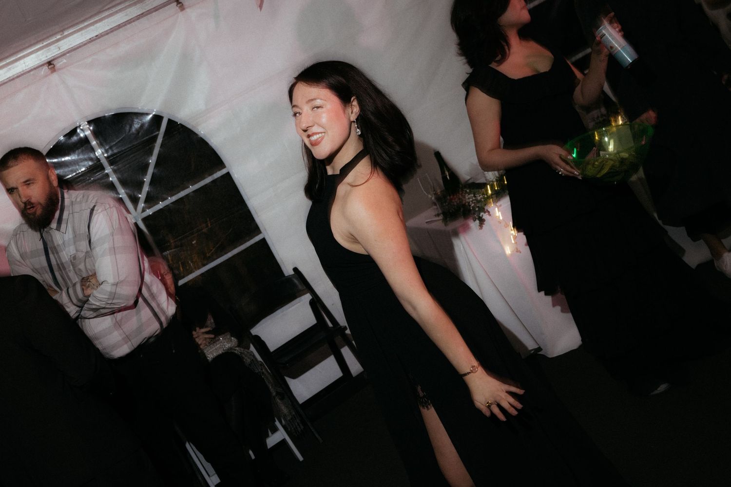 Partygoers enjoying themselves in a dark venue with ambient lighting.