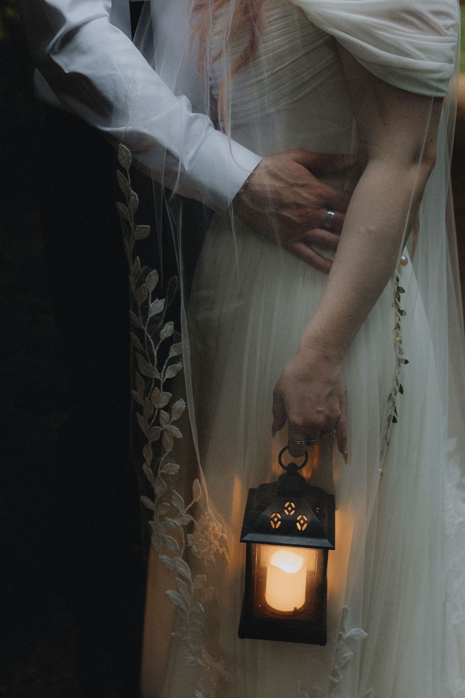 A glowing lantern with cat-like eyes creates a magical ambiance against white flowing curtains in a dark setting.