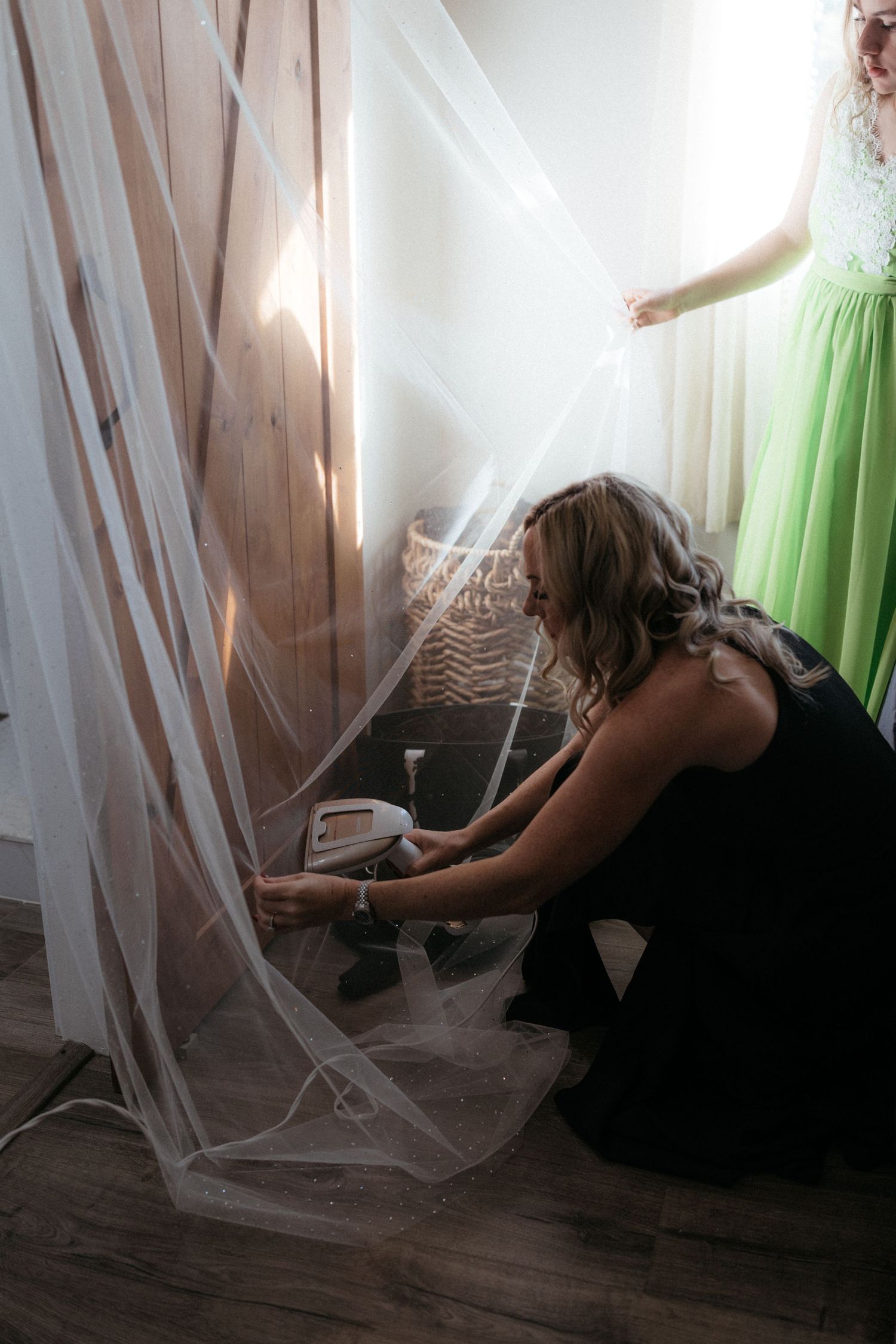 A series of moody photos showing a person sitting behind sheer curtains in a dark room with dramatic lighting.