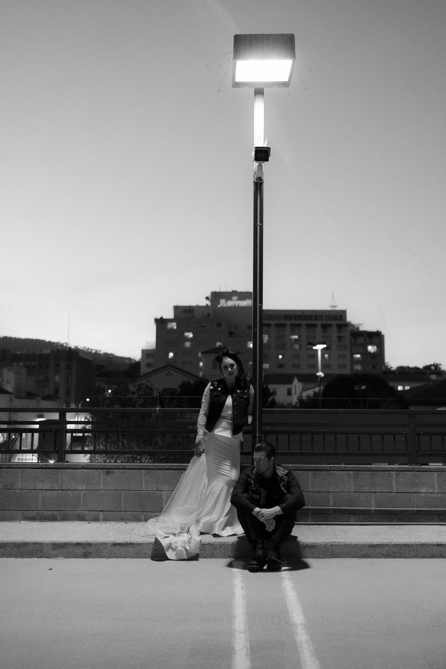 Black and white urban rooftop sequence with city buildings in background.