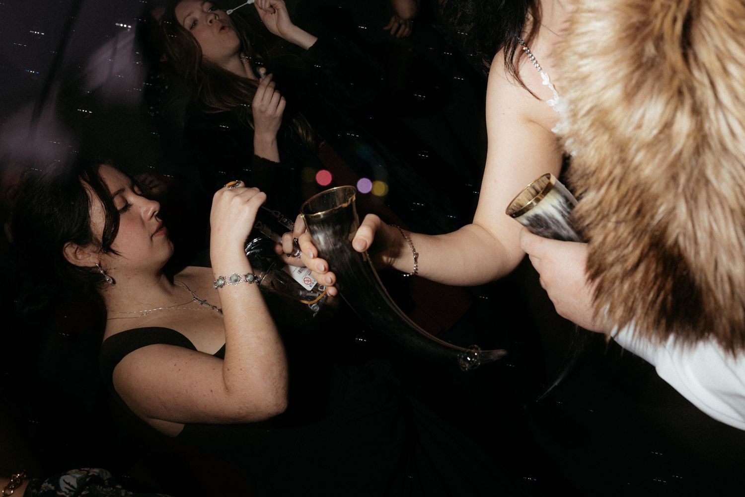 Partygoers dancing and having fun at a nighttime wedding celebration.