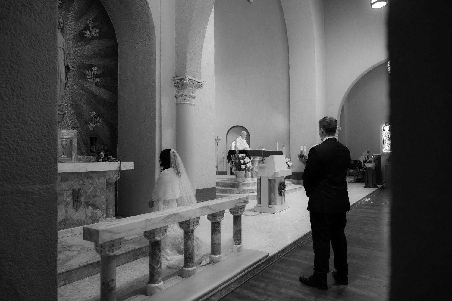 Side view of a church altar during a wedding ceremony in dramatic lighting.
