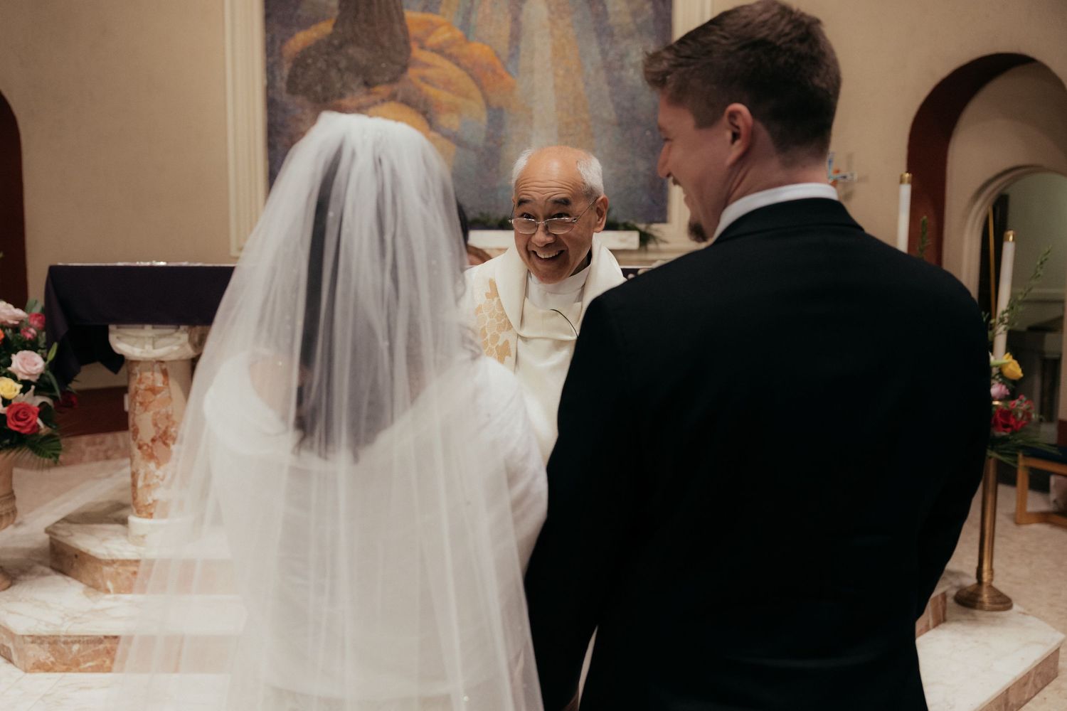 A wedding ceremony takes place at the altar of a traditional church.
