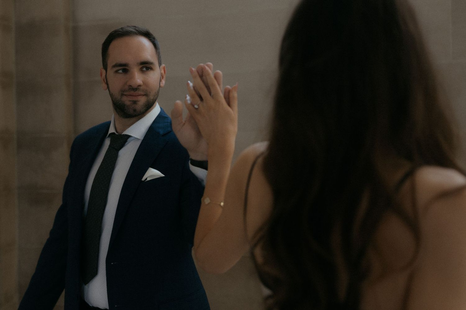 A couple in formal attire dances together in an elegant indoor setting.