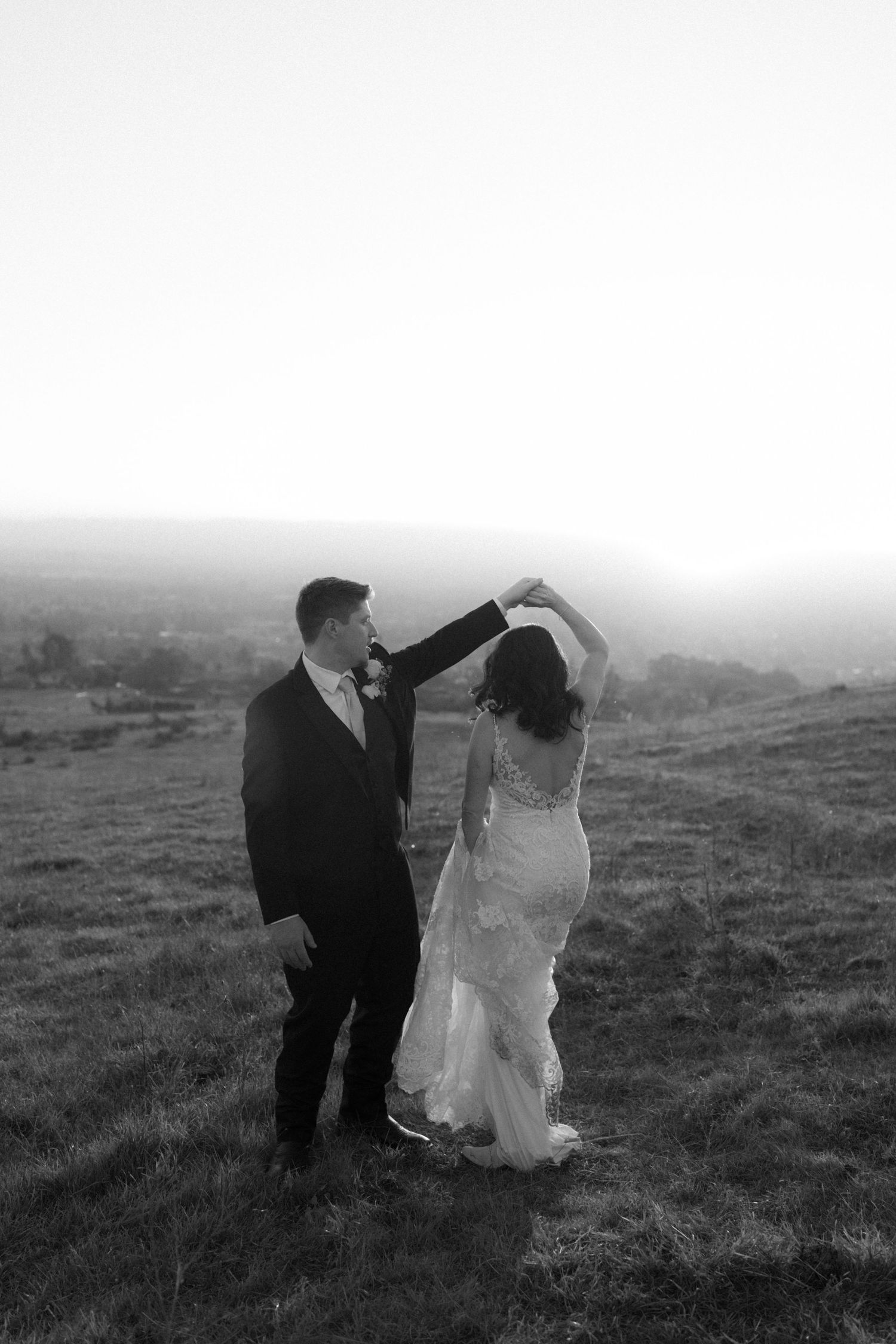 Black and white photos capture romantic moments between newlyweds in a countryside setting.