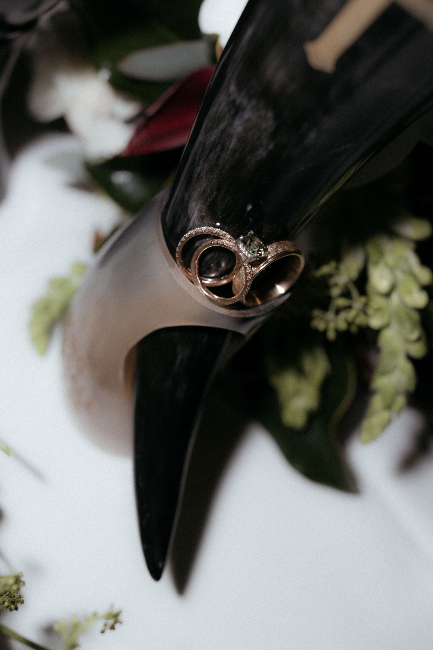 Close-up shot of a delicate rose gold wedding ring with intricate details against a dark background.