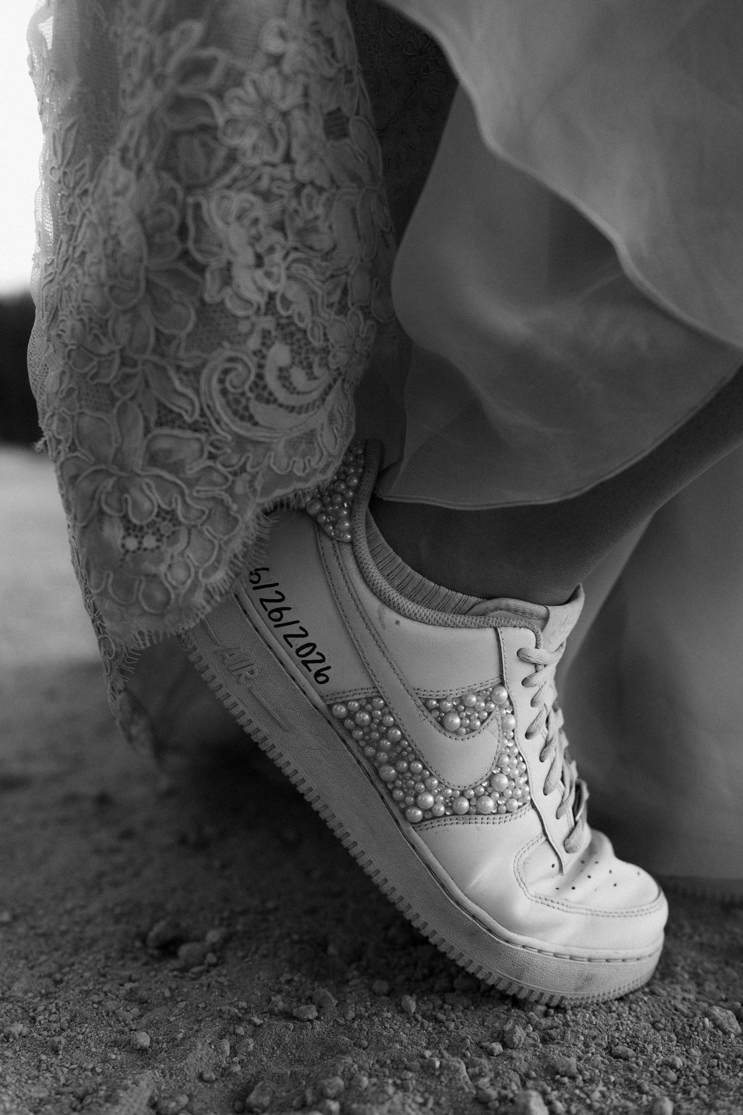Custom pearl Nike Air Force 1 sneakers with wedding date worn by bride.