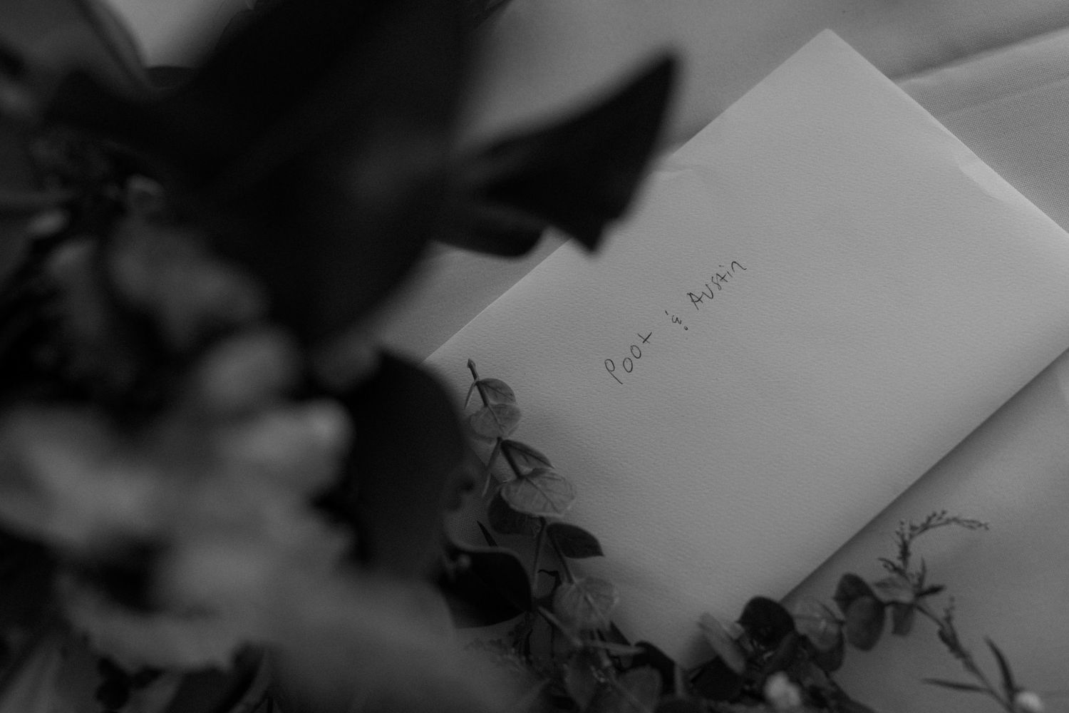Black and white image of handwritten notes and wedding reception details on a table.