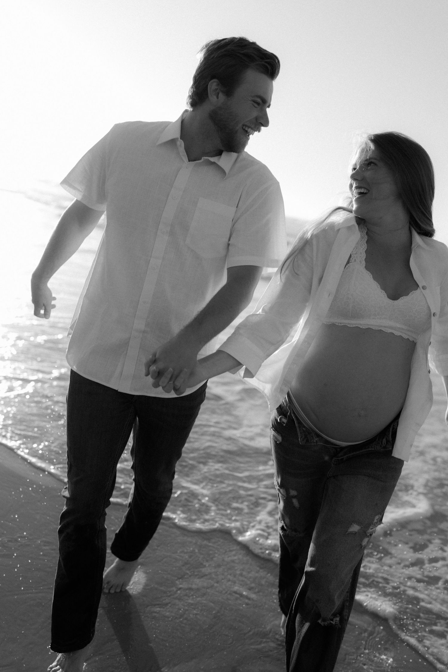 Black and white photo series of a couple dancing together on a beach with joyful movement and energy.