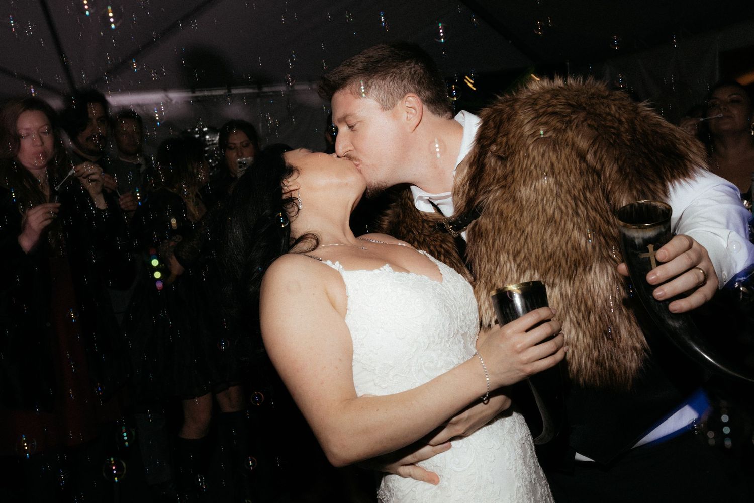 A couple shares an intimate dance moment under dim reception lighting.