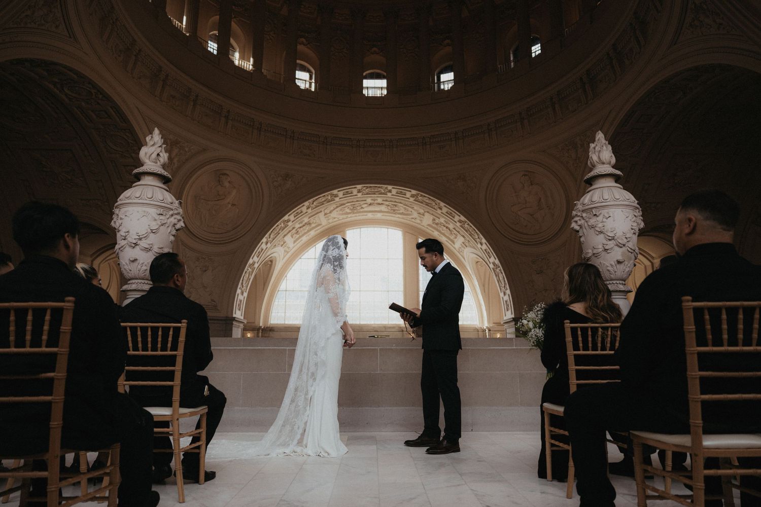 An elegant wedding ceremony setup in a domed room with classical architecture.