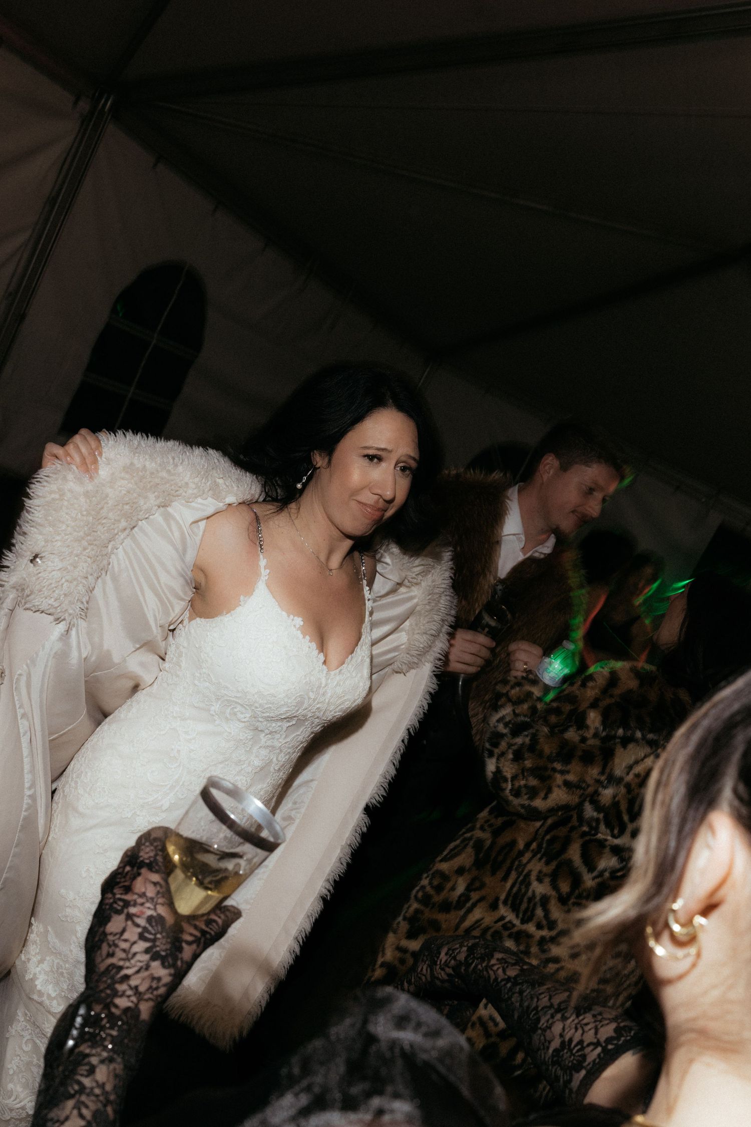 Person in a white dress dancing and moving at a nighttime celebration.