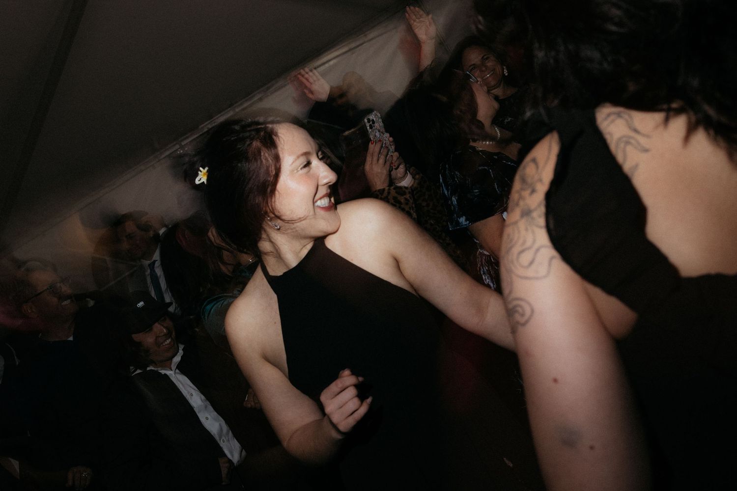 A dark, intimate dance scene shows silhouettes of people moving together on a crowded dance floor.
