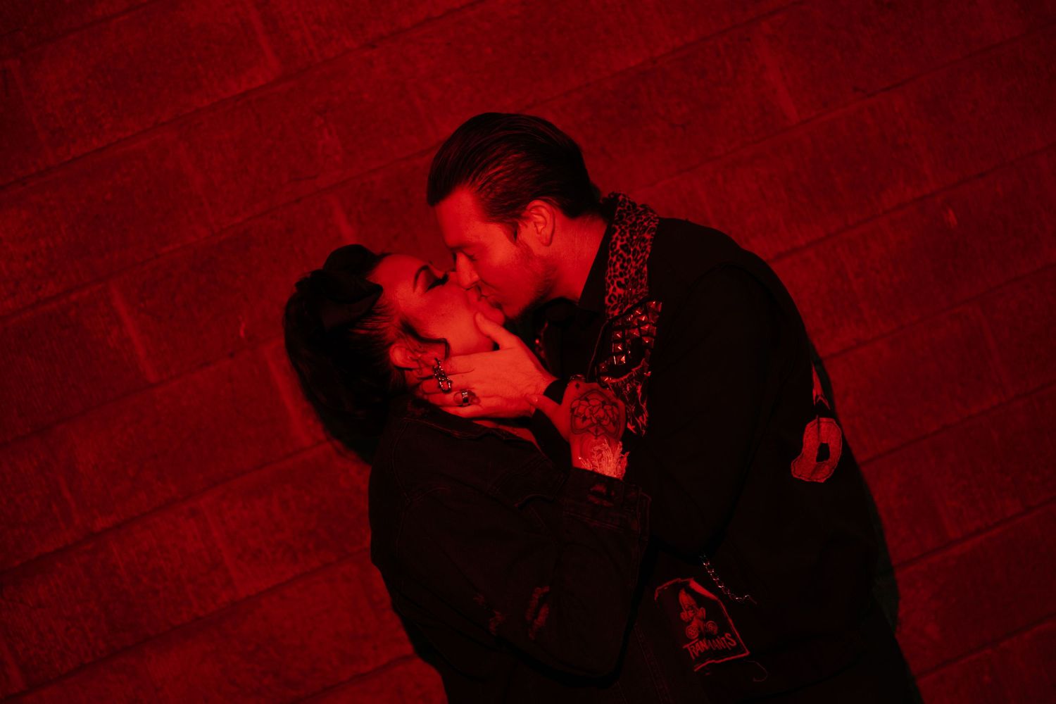 An artistic series of silhouettes showing a couple in an intimate moment against a red background.