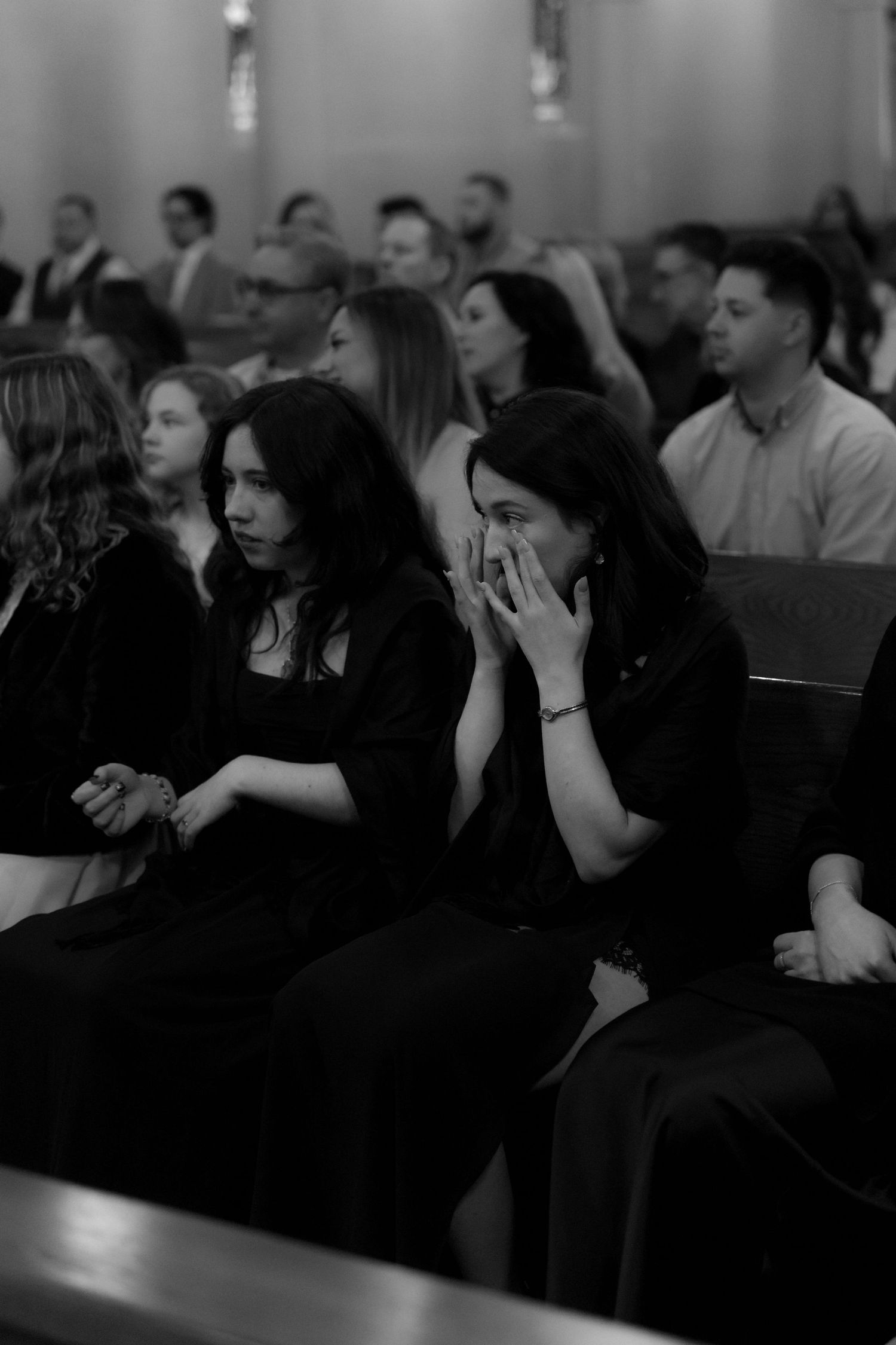Wedding guests seated in church pews during an emotional ceremony.