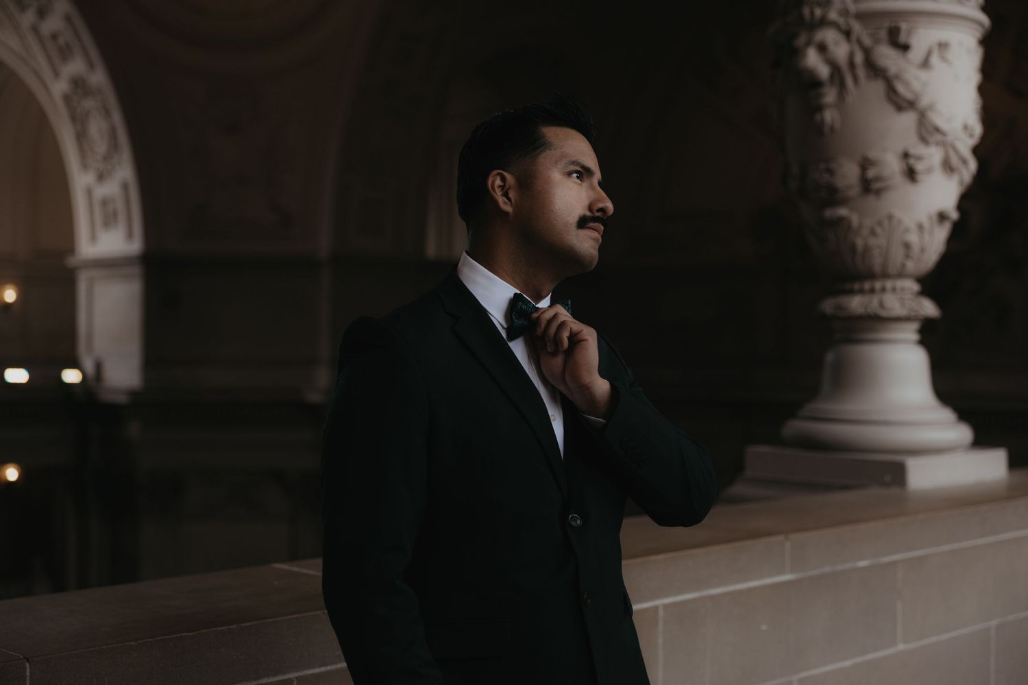 Dramatic architectural wedding photography in a historic building with stone columns.