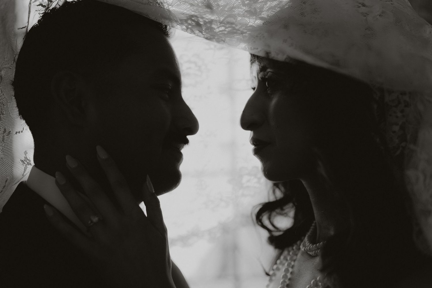 A silhouetted profile of newlyweds in an intimate black and white portrait.
