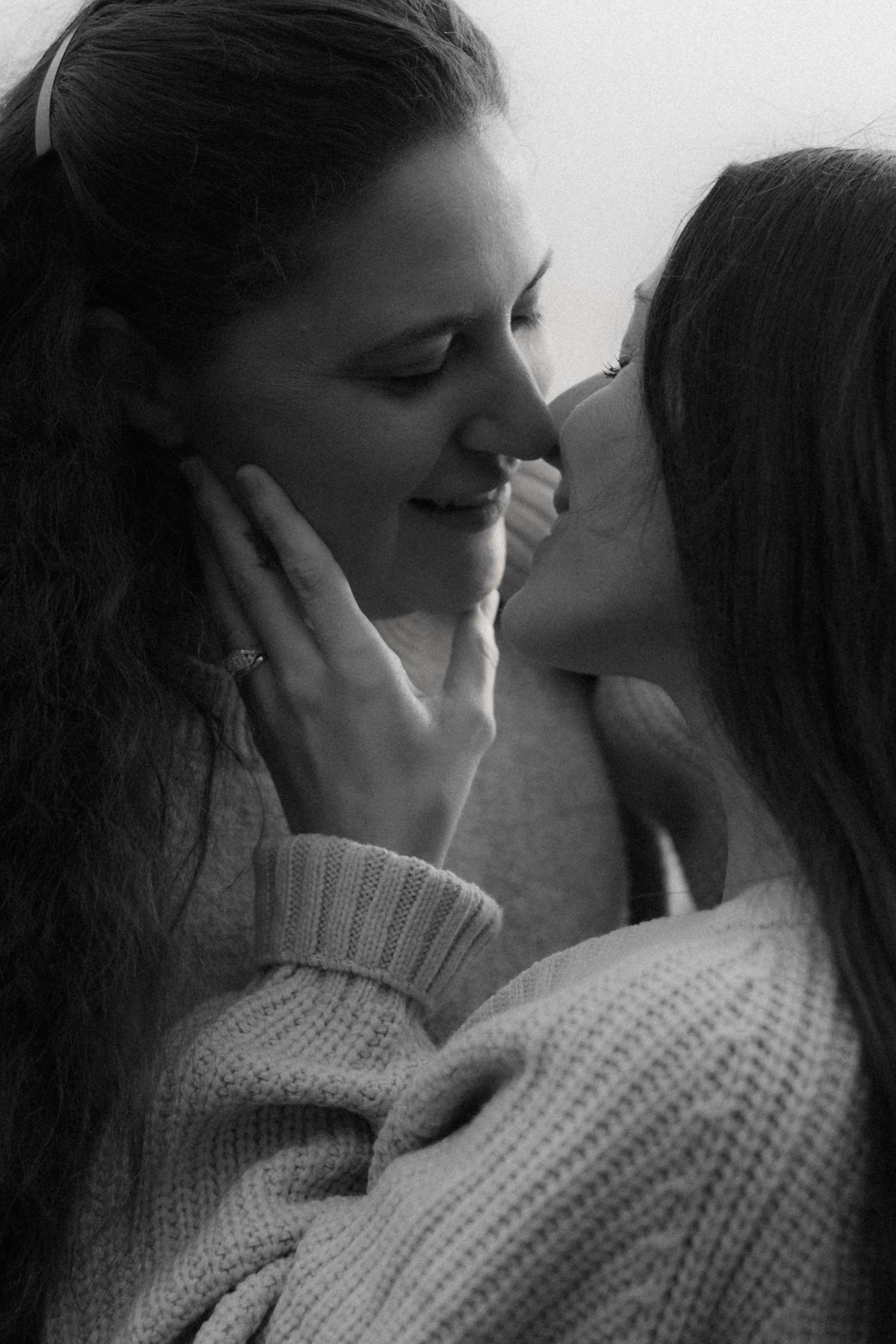 A romantic black and white photo series showing an intimate couple in cozy sweaters sharing tender moments.