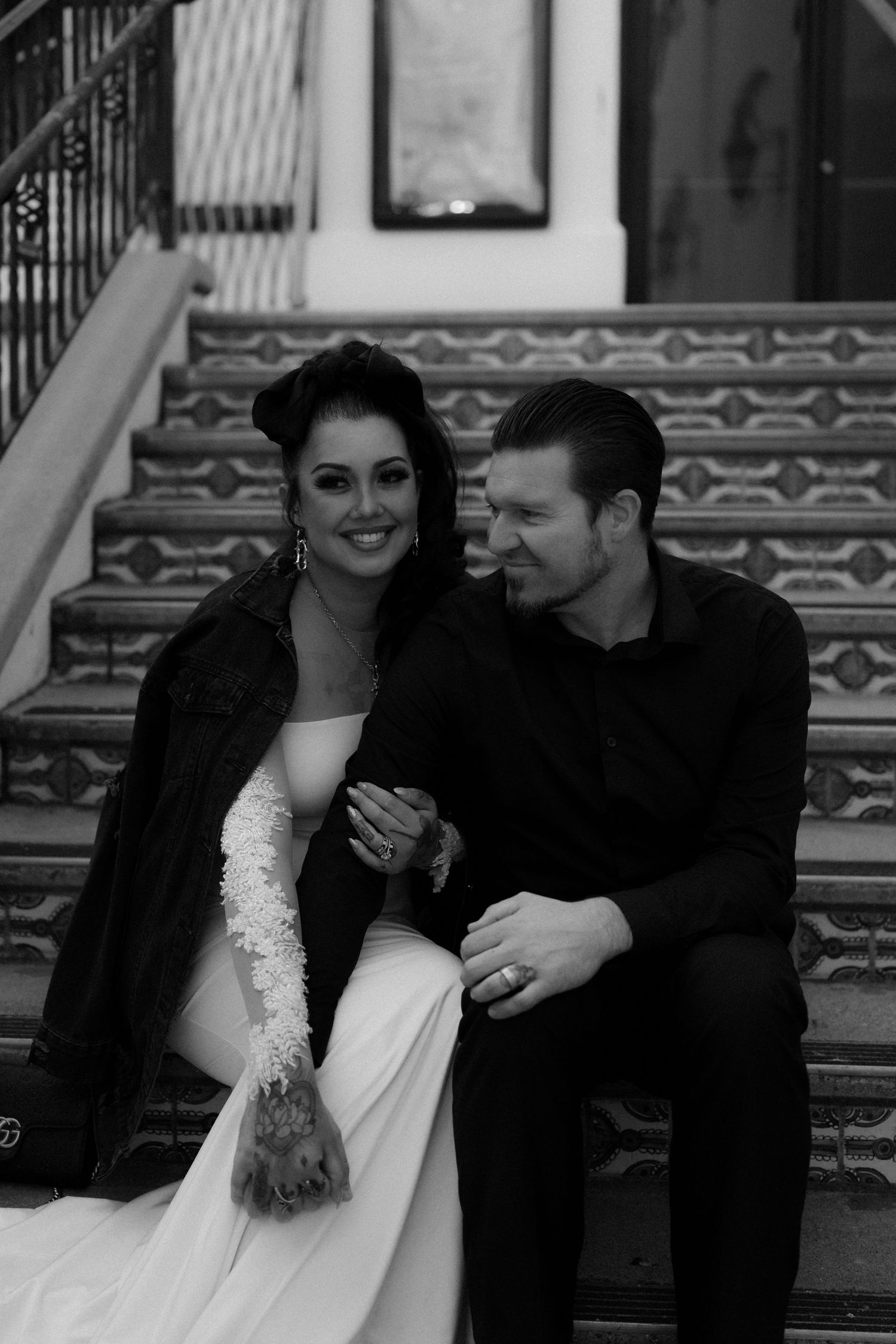 A romantic moment shared between a couple sitting on patterned steps.