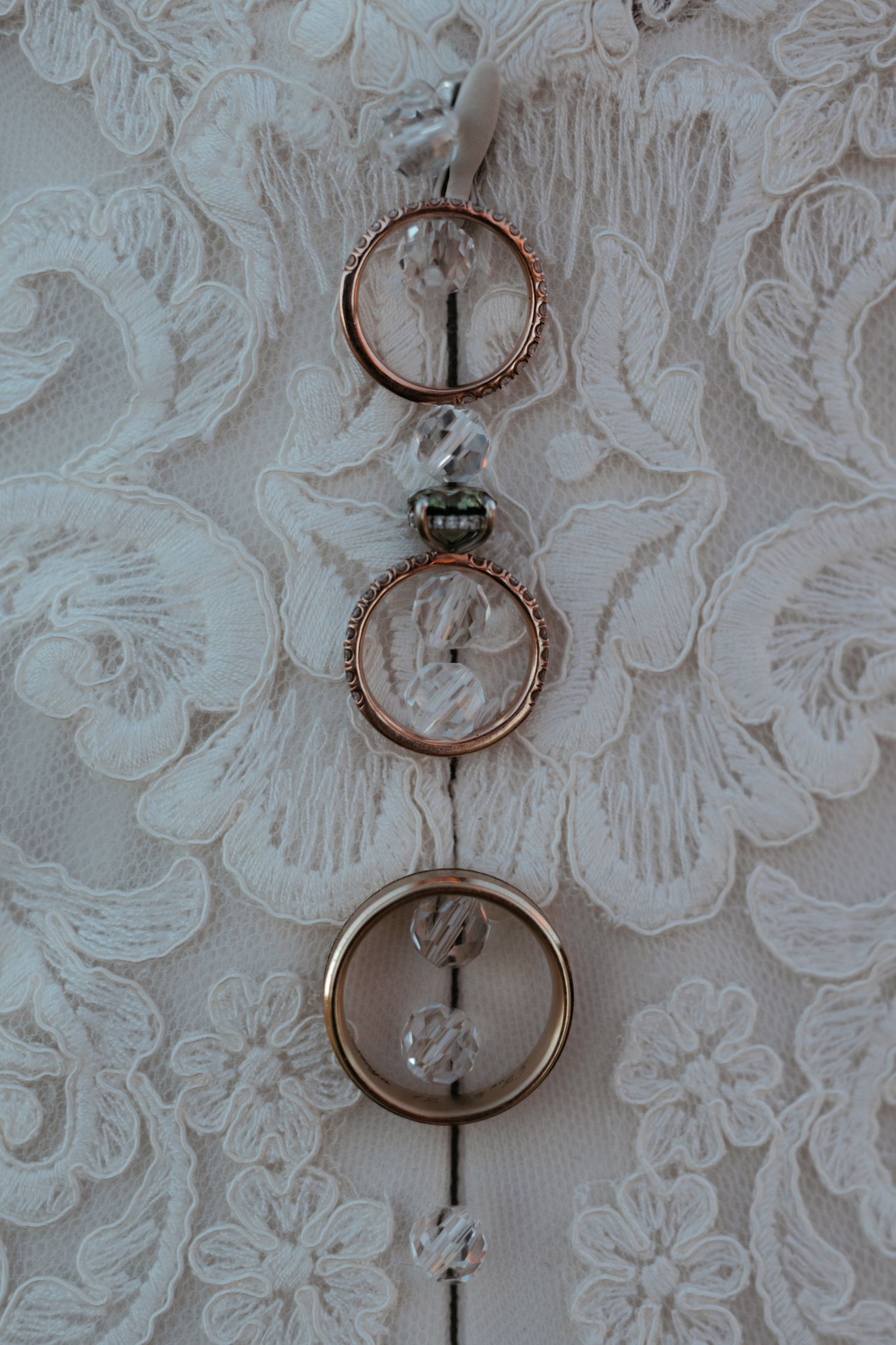 Wedding rings delicately arranged on white lace fabric creating an elegant bridal detail shot.