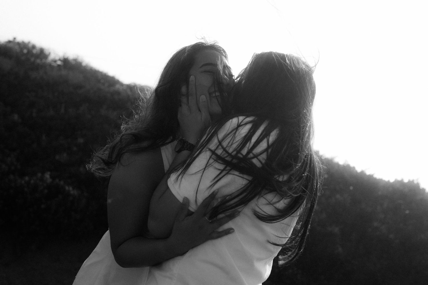 A black and white photo sequence shows a couple embracing and kissing in silhouette against a bright background.