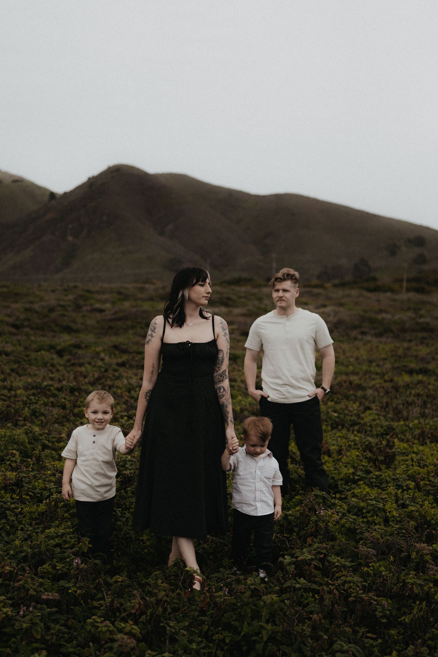 A family walks together through a scenic mountainous landscape with green vegetation.