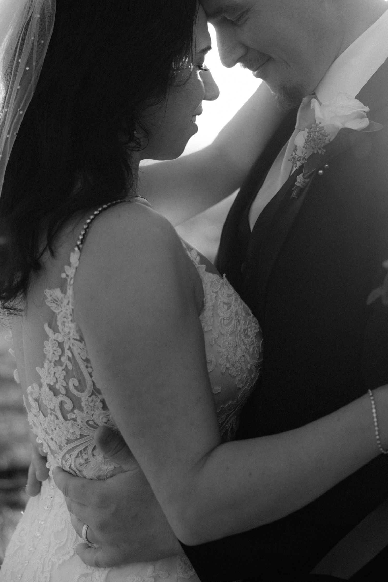 Close-up black and white photos capturing tender moments between bride and groom.