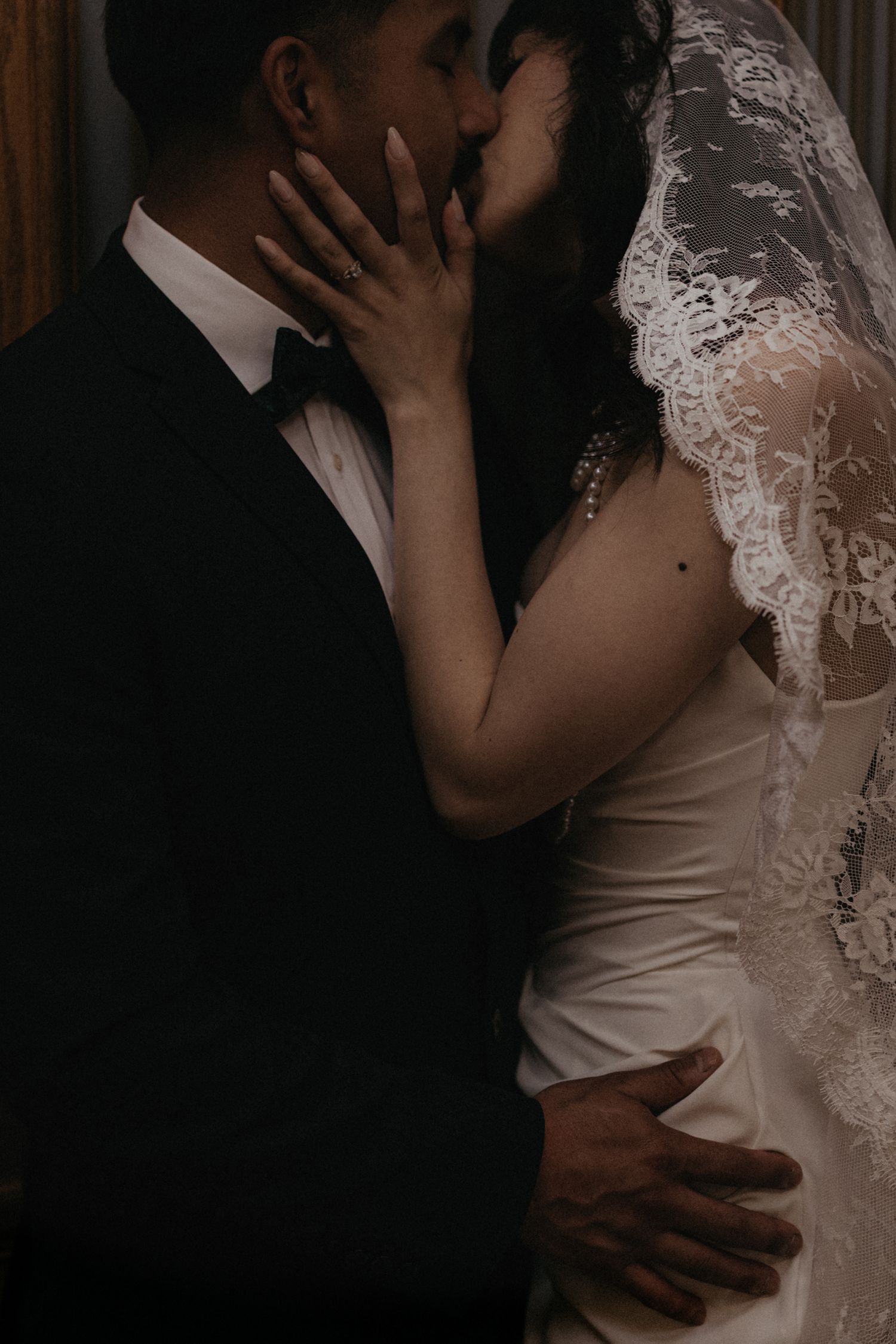A romantic black and white photo of newlyweds sharing an intimate moment.