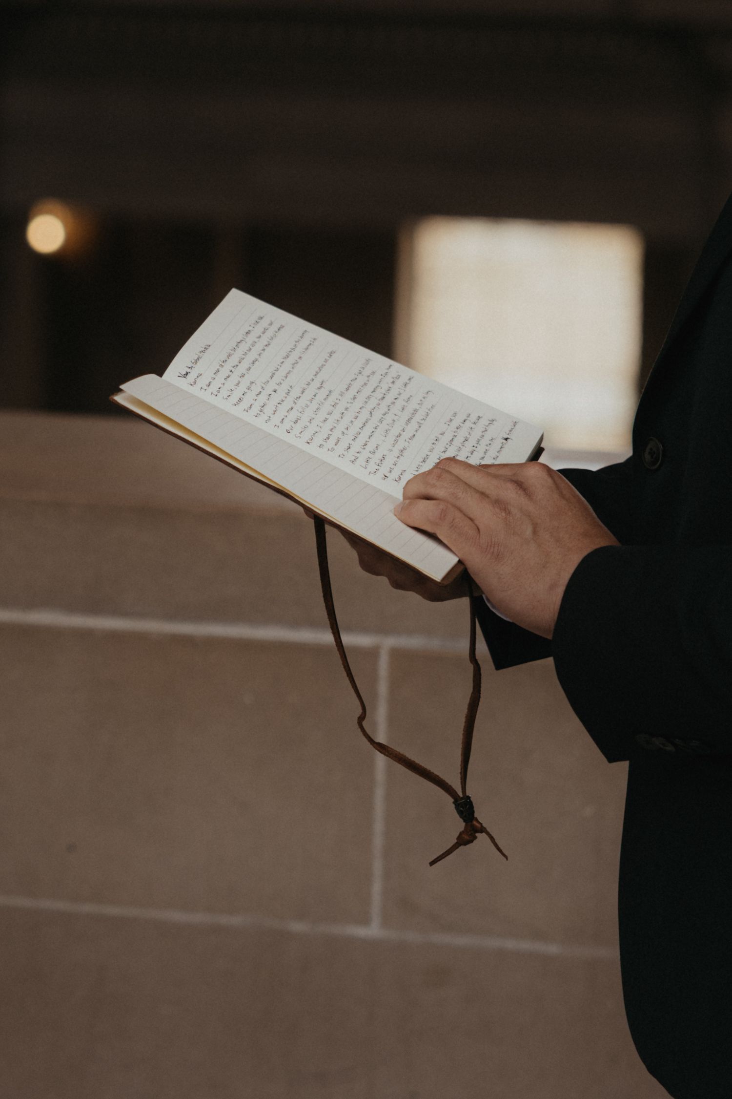 Hands holding a book or ceremony program against a light background.