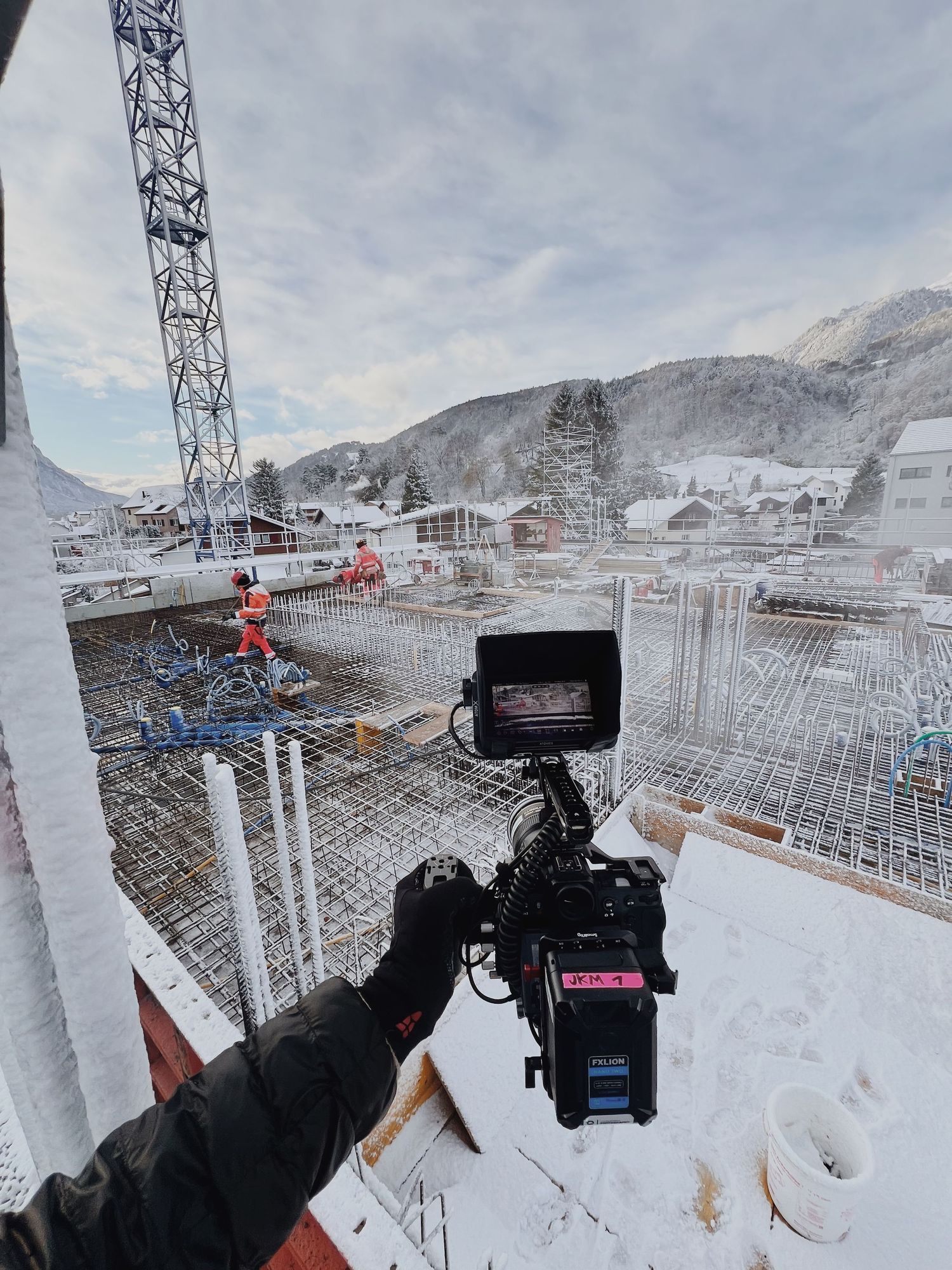 Snow-covered construction site being filmed with professional camera equipment.