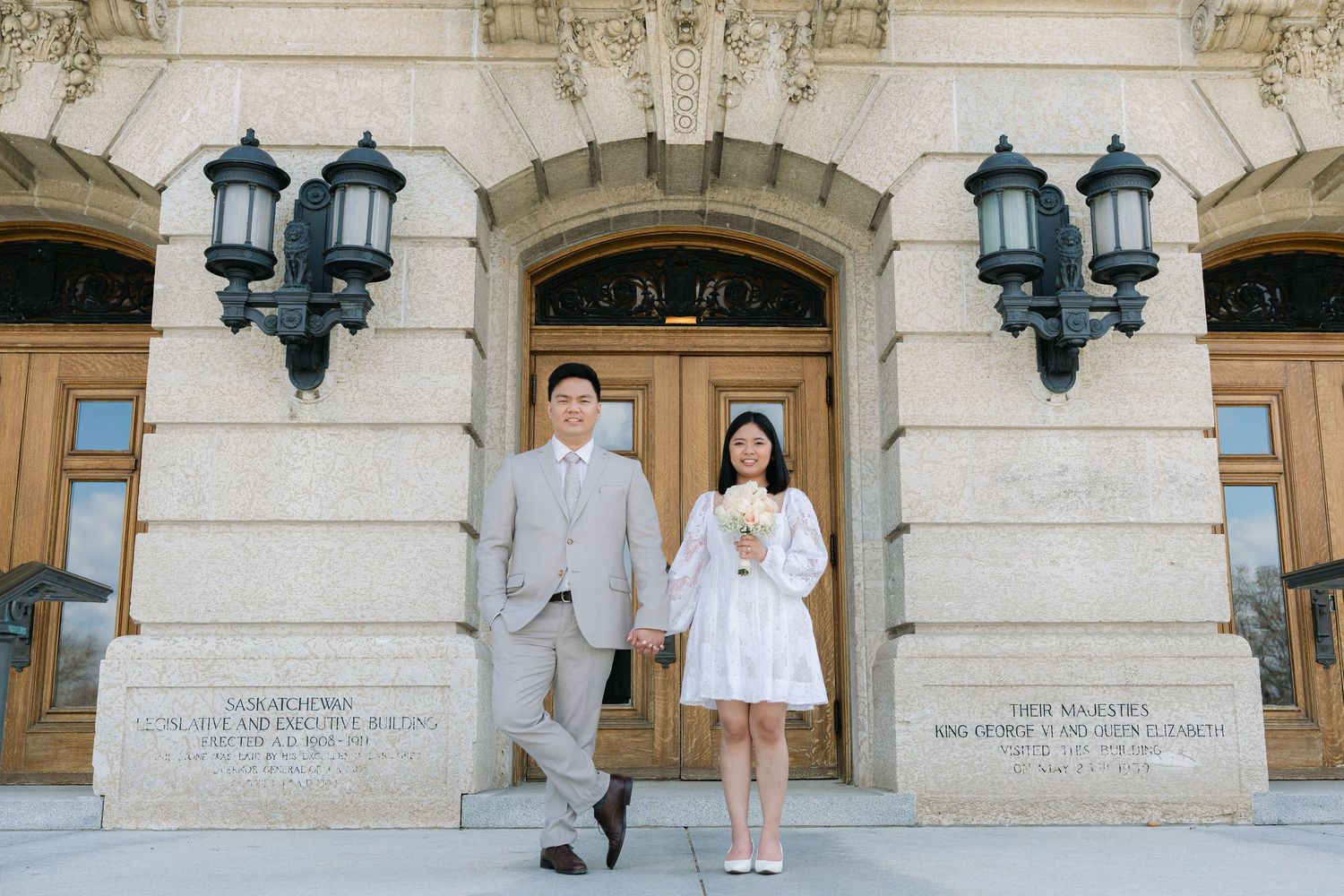 bride and groom standing at the entrance of a historic building during a wedding portrait