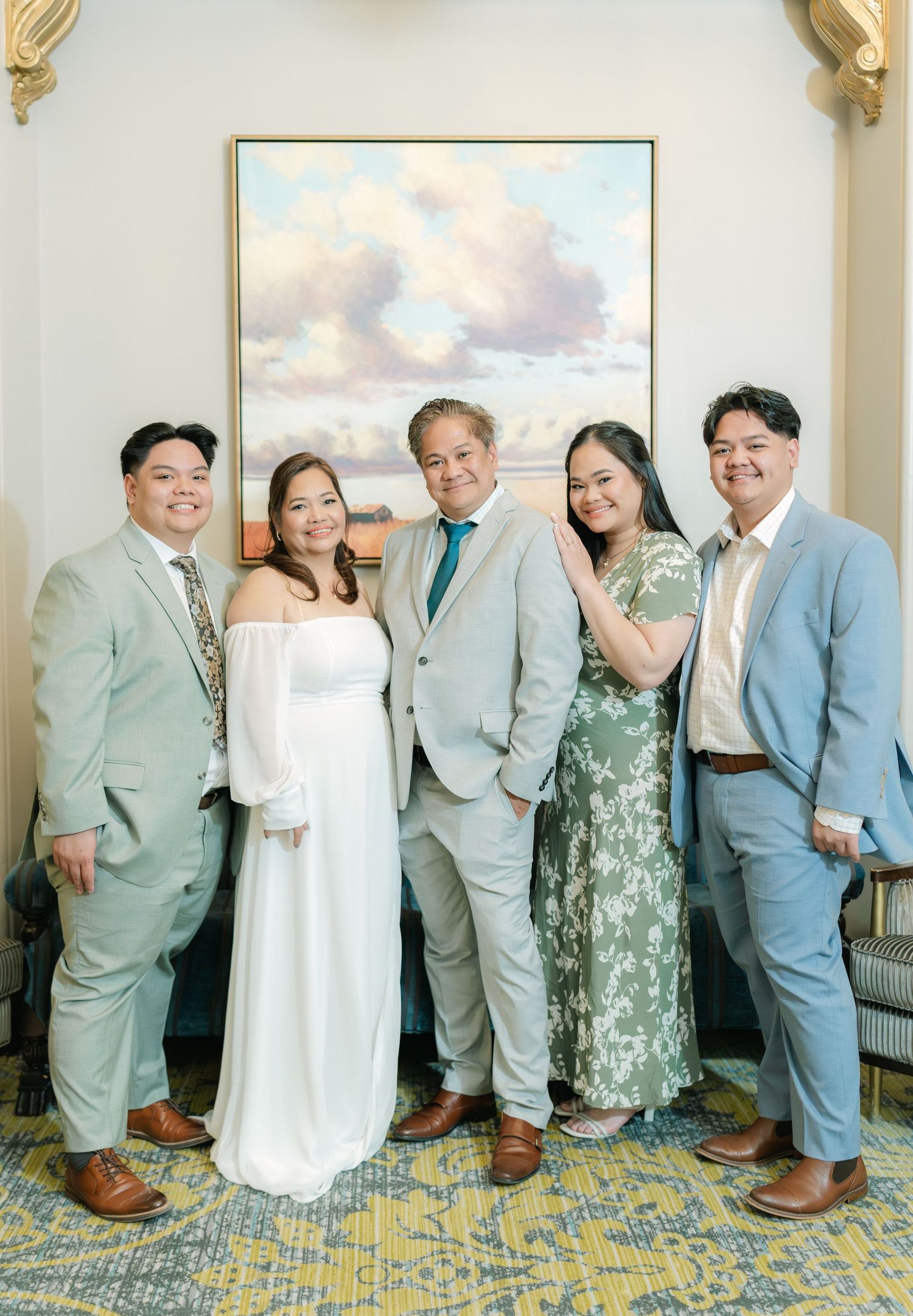 Couple celebrating their wedding anniversary with their children, posing together in front of a scenic backdrop and radiating love and joy