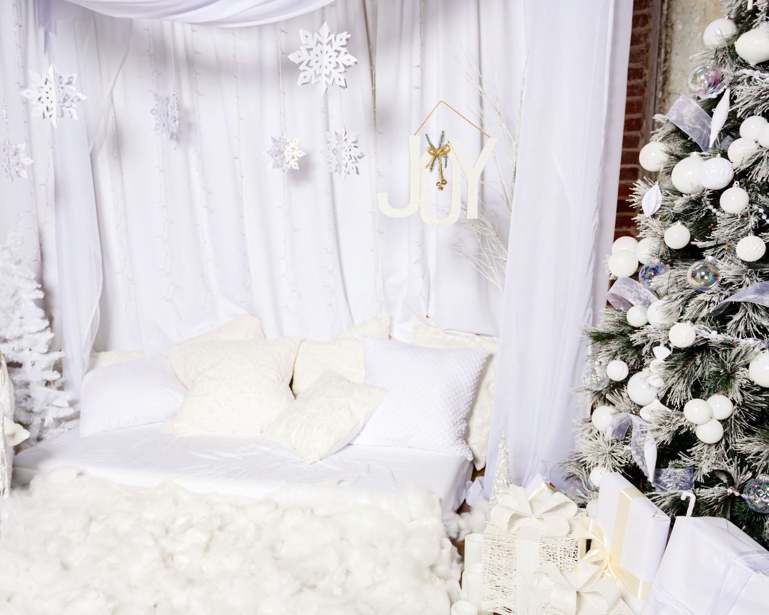 White Christmas themed wedding backdrop with snowflake decorations, floral arrangements and elegant drapery.