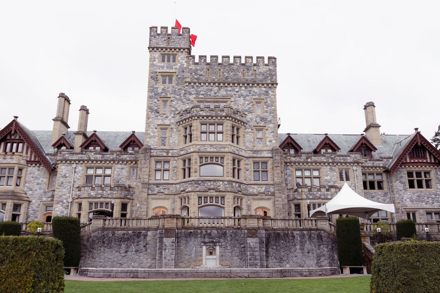 Panoramic view of a historic stone castle with Gothic architecture and crenellated towers in daylight.