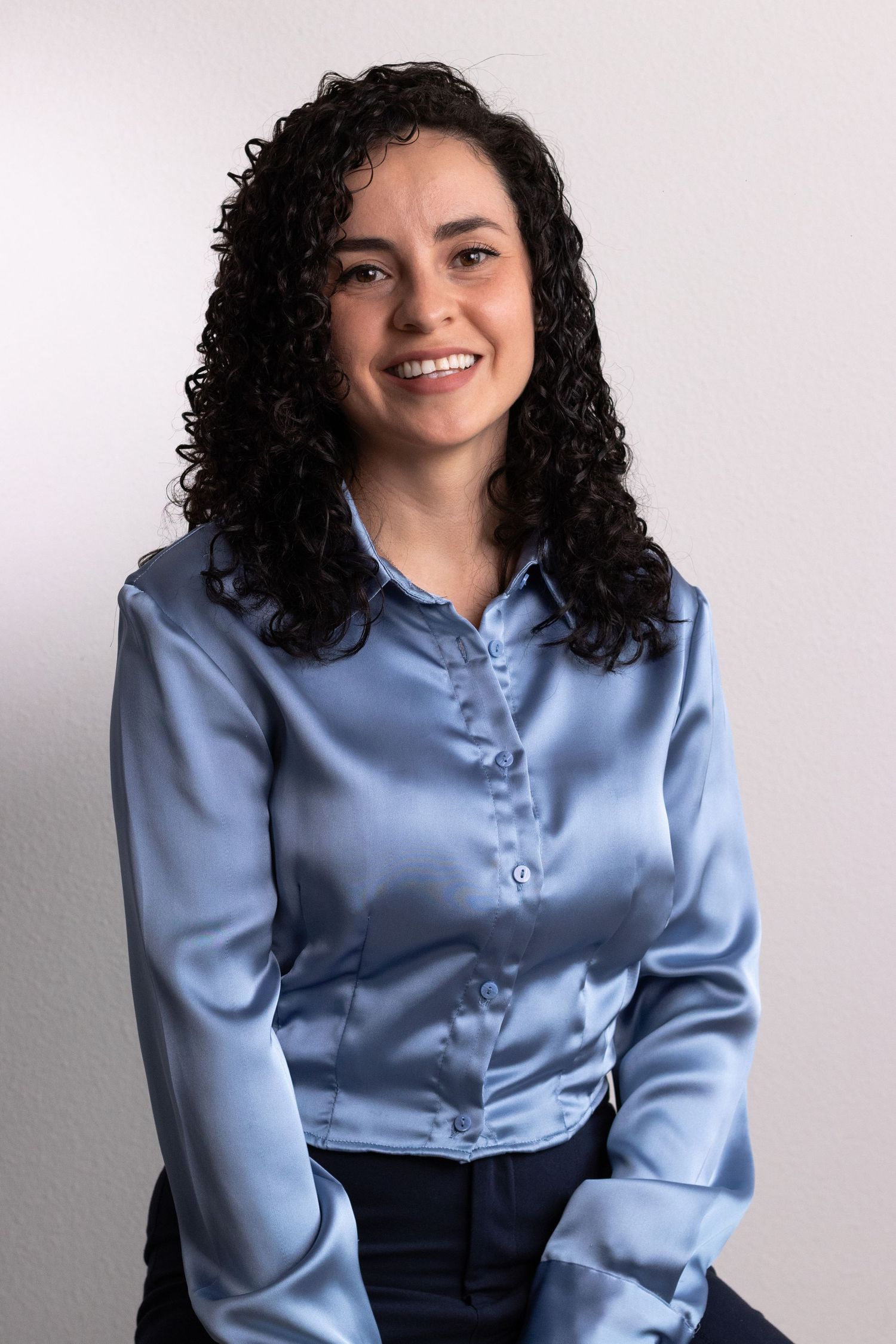Professional portrait series featuring light blue blouse and dark skirt in studio setting.