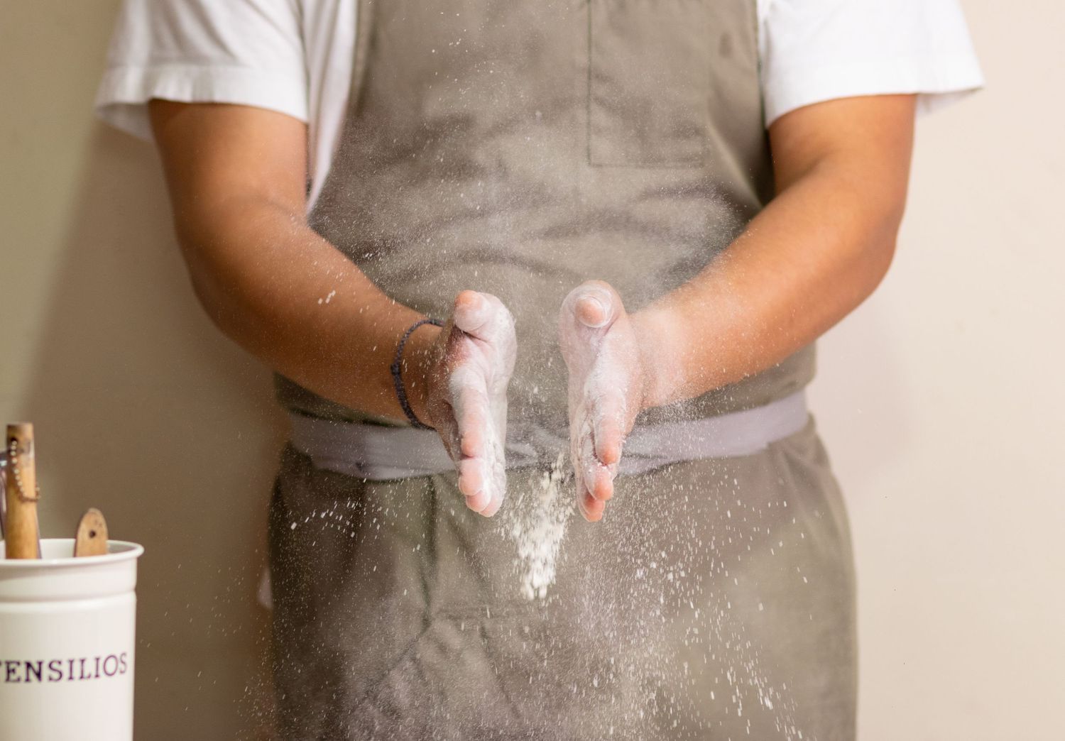 Close-up of hands working with flour and dough on a kitchen counter.