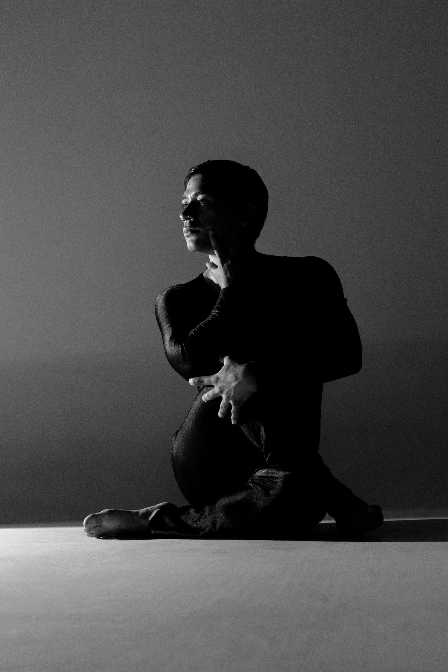 Minimalist black and white portrait series showing contemplative poses in low light.