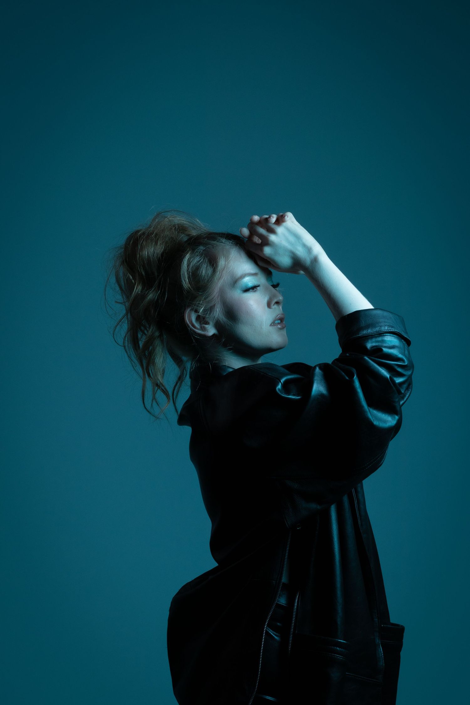 Artistic portrait series with dramatic blue lighting showing expressive poses against dark background.