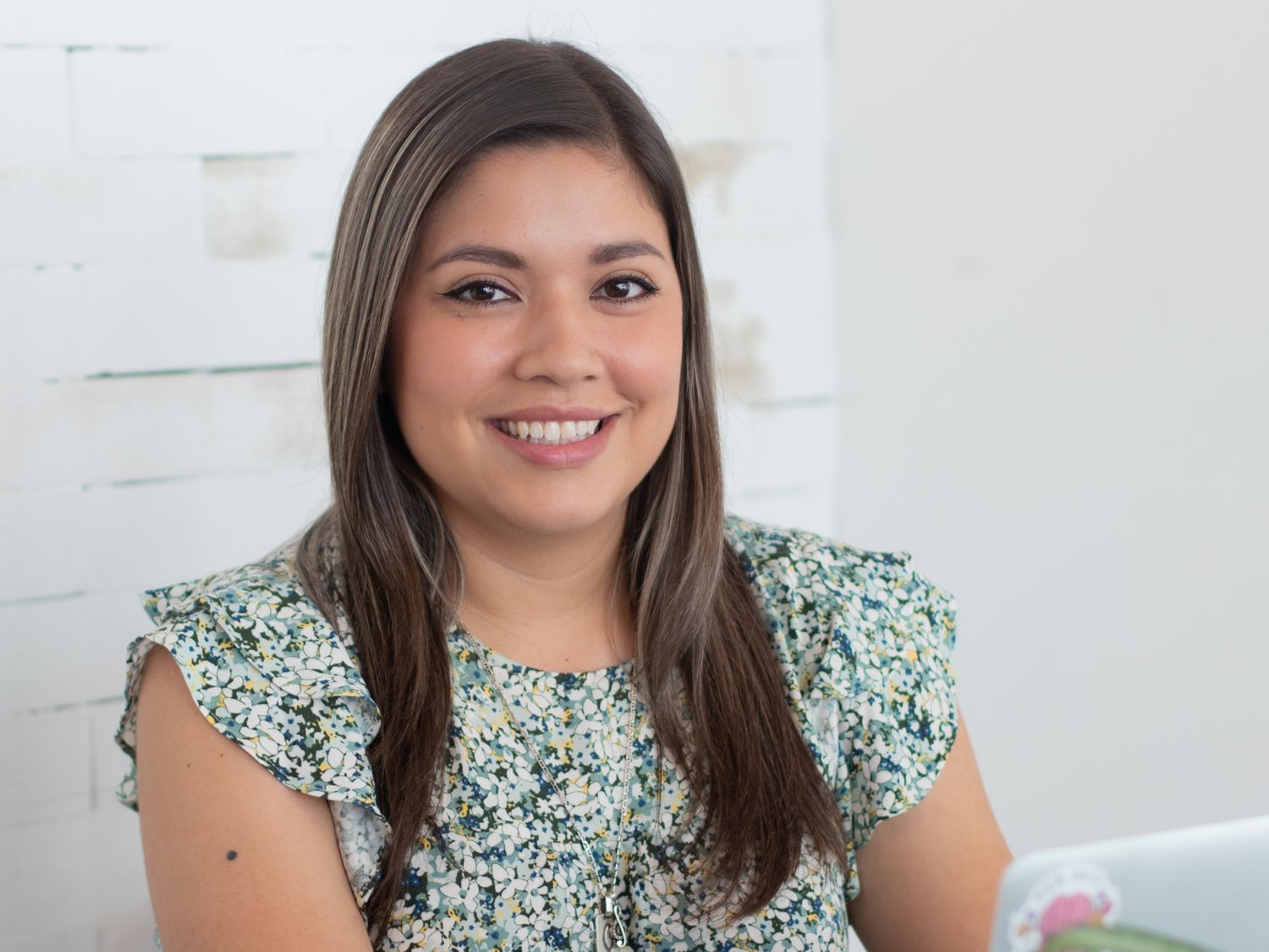 Professional headshots featuring floral print top and natural lighting.