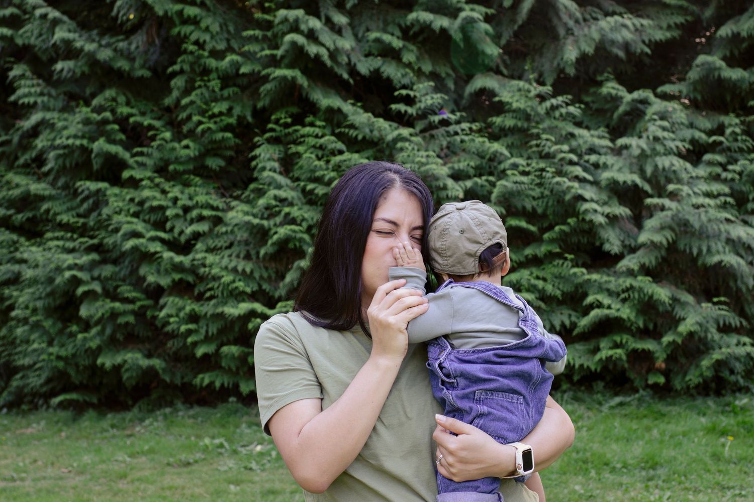 Sweet outdoor interaction with baby against lush green hedge background.
Central Park Burnaby
