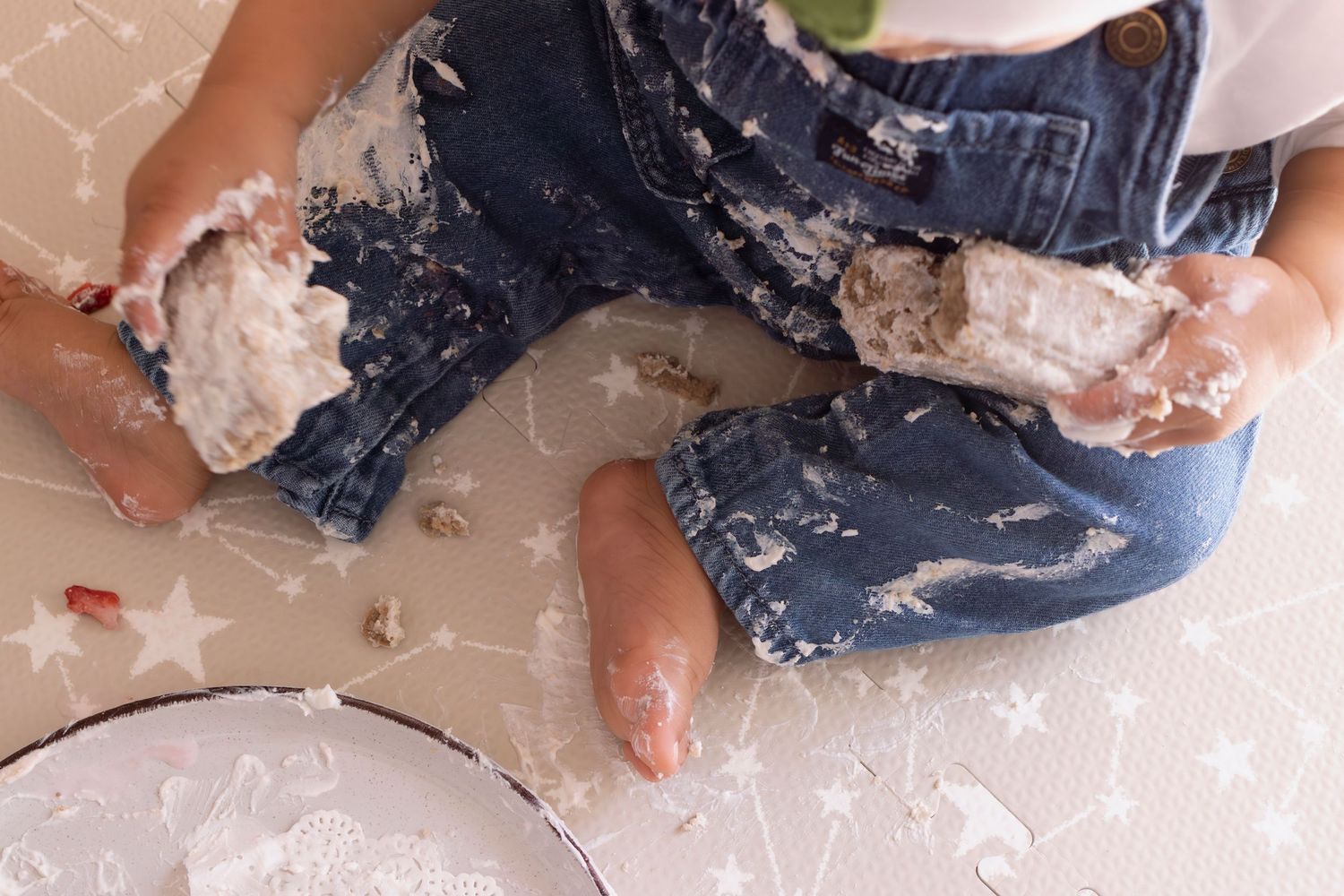 A small child plays with a messy mixture of flour and water on a kitchen counter while baking.