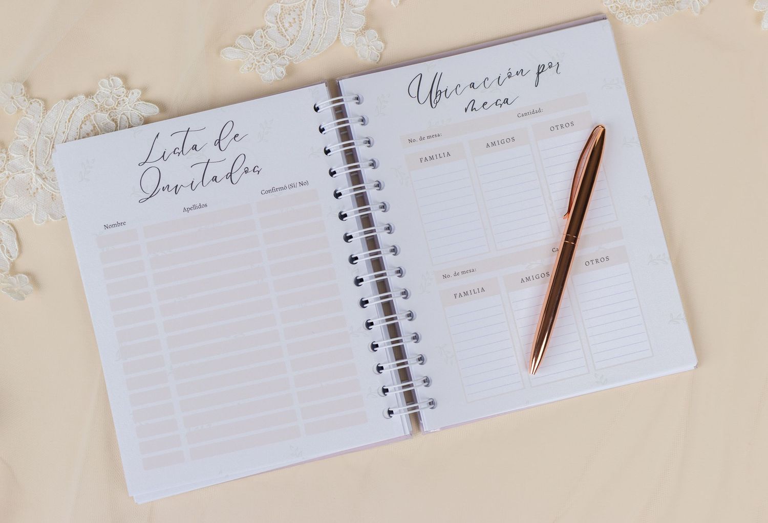 Open spiral wedding planner notebook with guest list and timeline pages, rose gold pen on beige background.