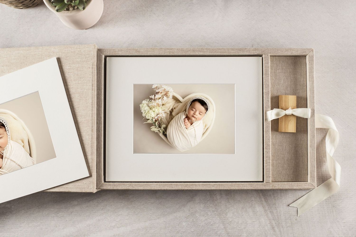 Elegant newborn photo display in a linen keepsake box with matted print and USB drive, perfect for preserving precious memories.