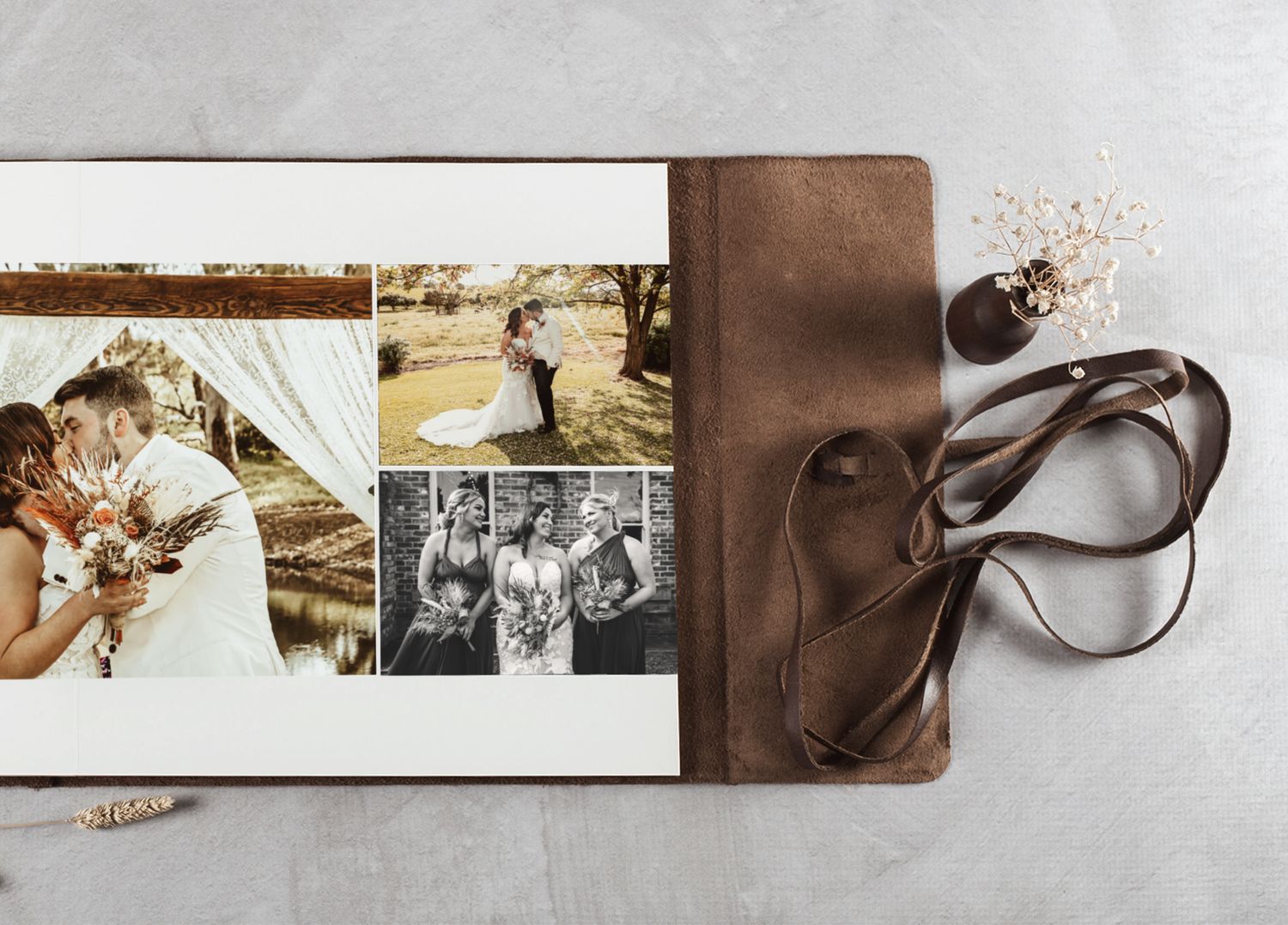 Elegant leather-bound wedding photo album open displaying romantic couple and bridal party black and white photographs.