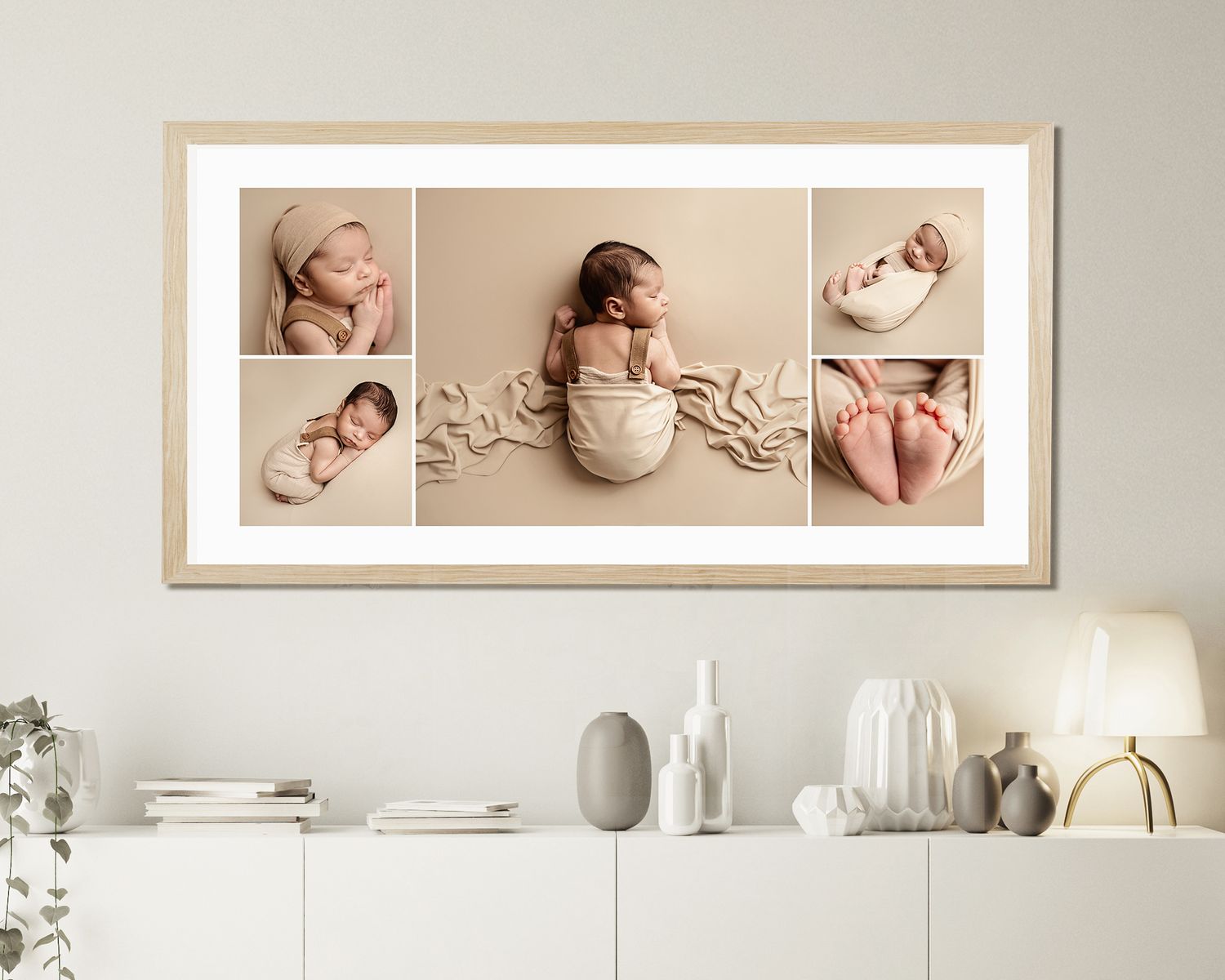 Framed newborn photo collage with four beige-toned images of a sleeping baby, displayed above a white sideboard.