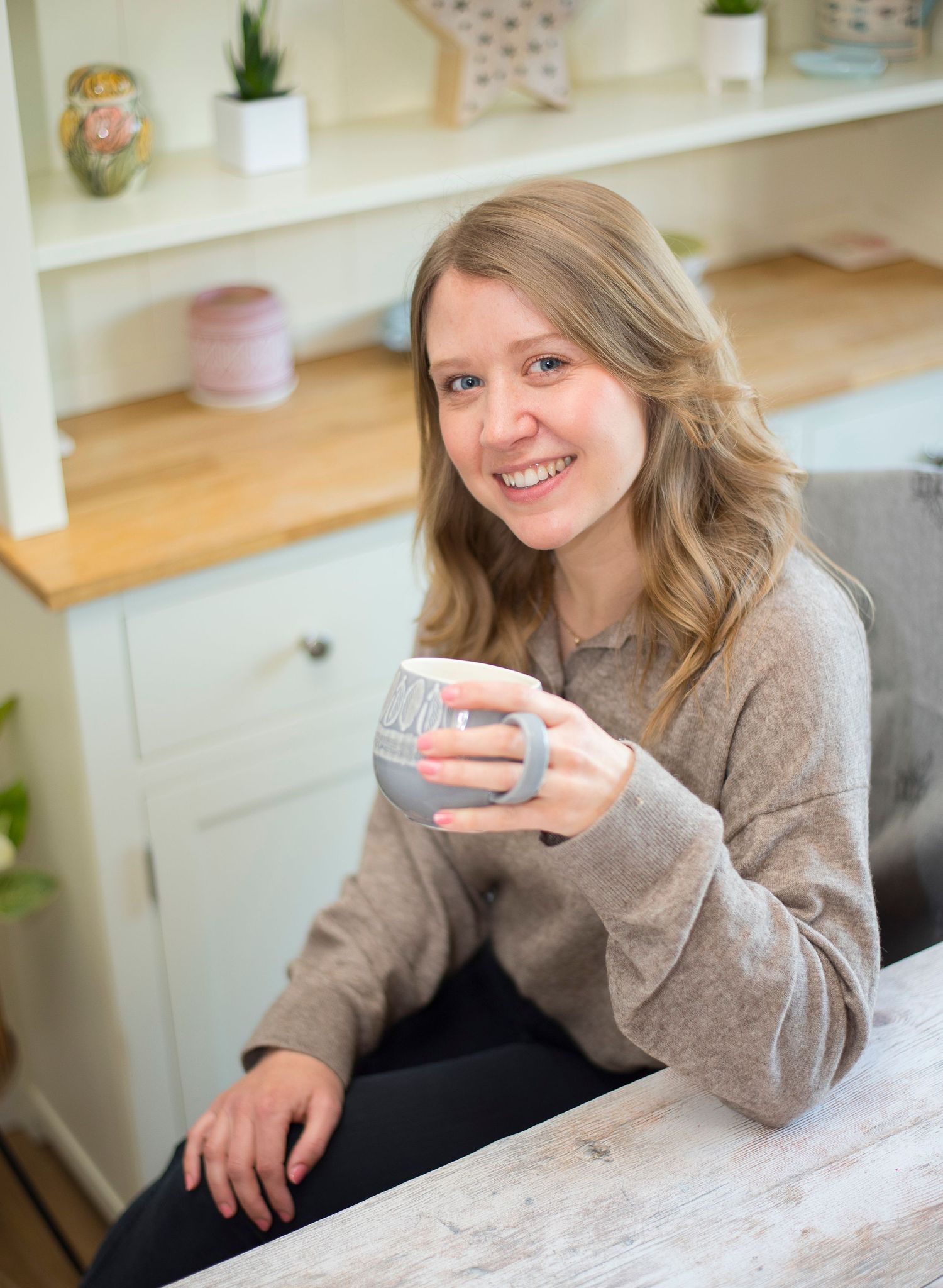 female business owner holding a cup smiling