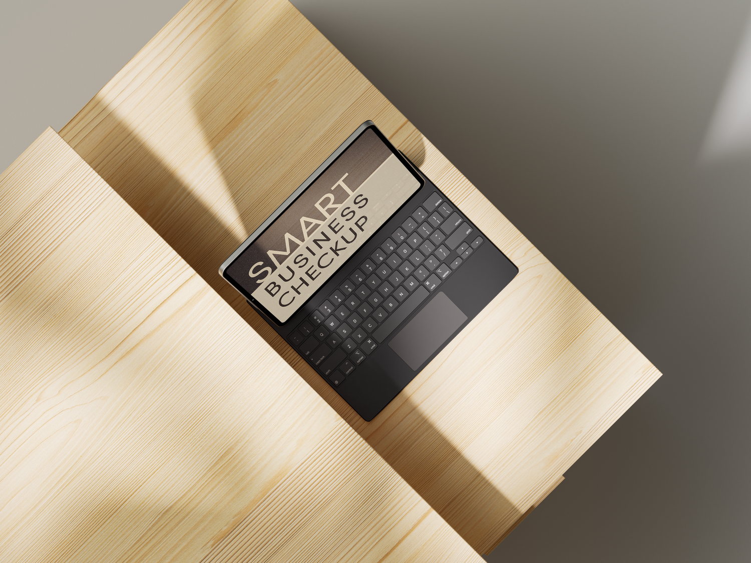 Black wireless keyboard positioned on light wooden desk with diagonal sunlight creating dramatic shadows.