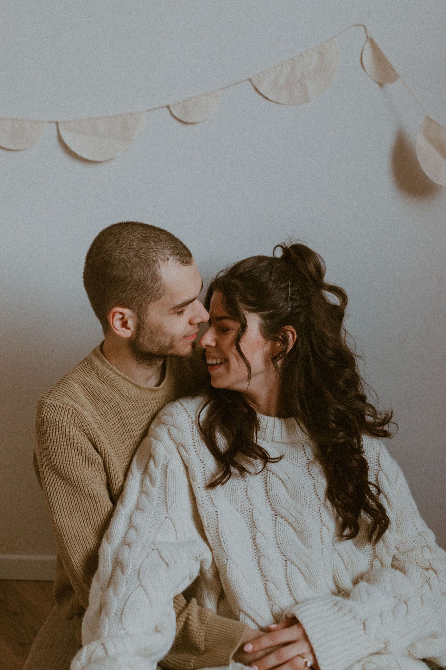 A romantic couple in cozy sweaters sharing intimate moments in a series of tender embraces against a light background.